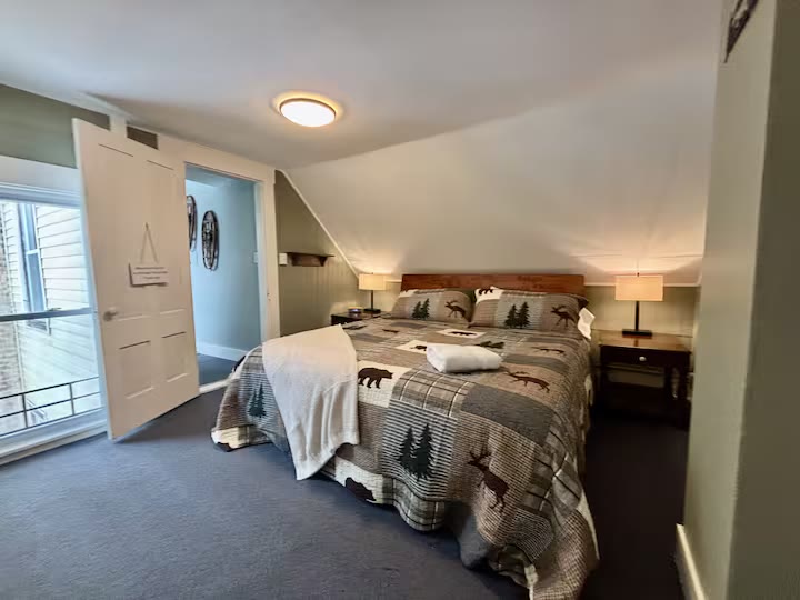 Bedroom with rustic quilt under a slanted ceiling