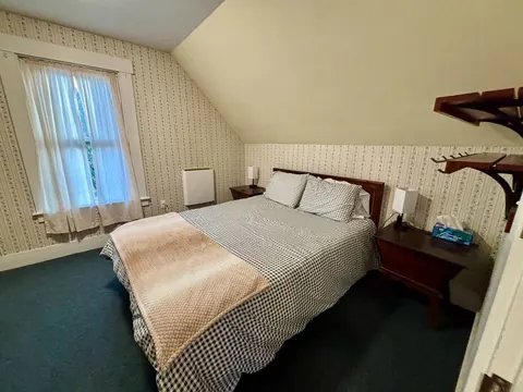 Second queen bedroom with white paneled walls